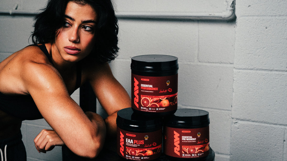 Sara Saffari leaning on a weight stack beside her Sour Blood Orange signature stack
