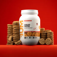 BUM Itholate Protein Peanut Butter Cookie tub surrounded by stacks of peanut butter cookies on a red background.