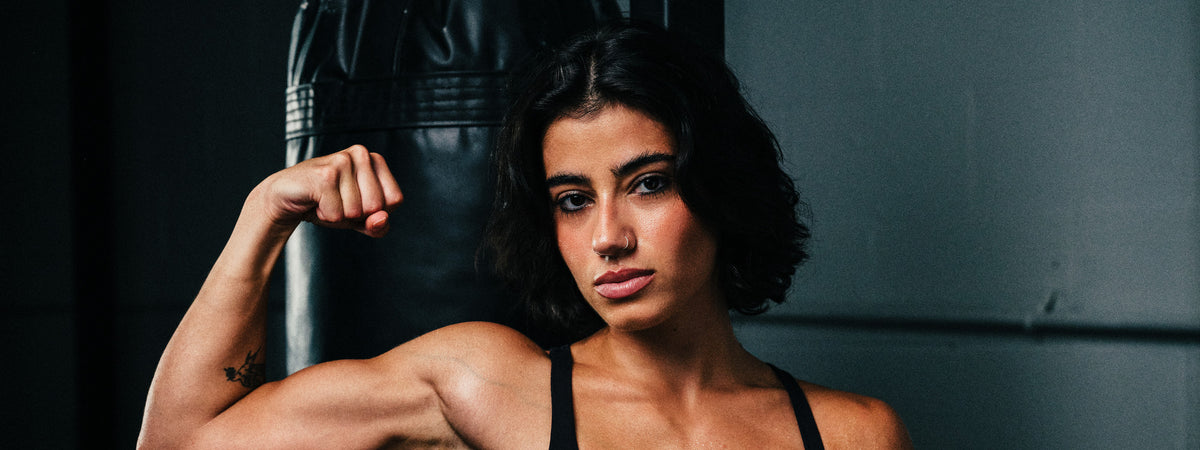 Sara Saffari flexing beside a punching bag
